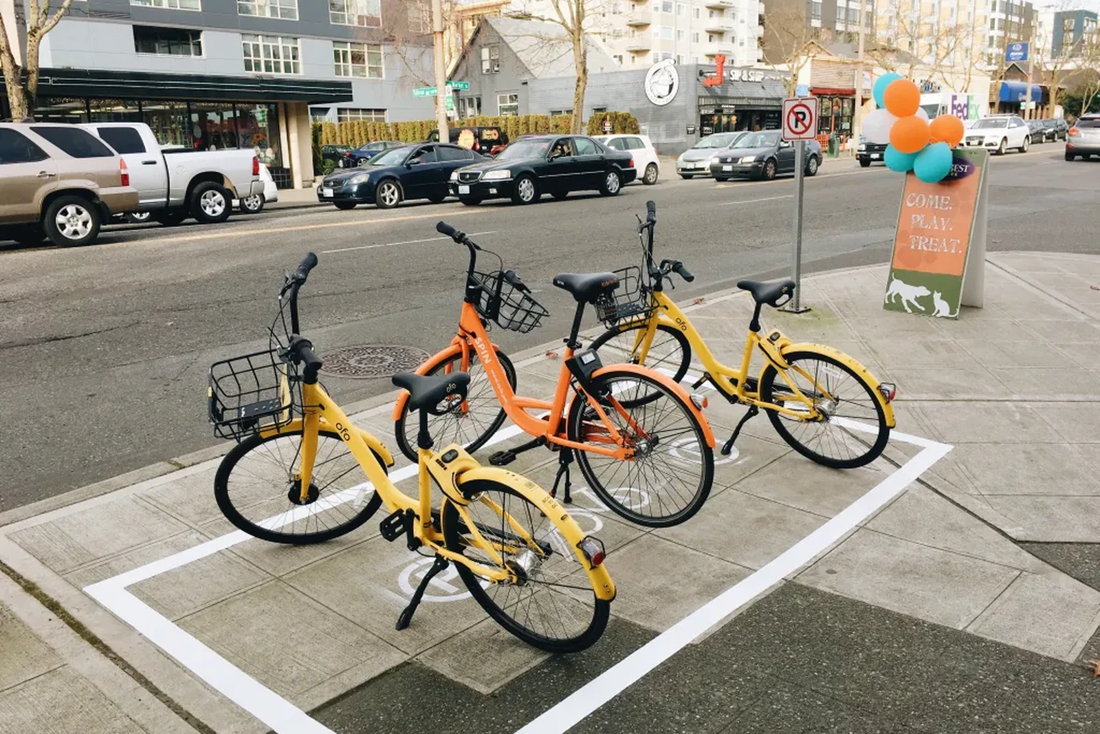 Three rental bicycles parked on a busy city sidewalk