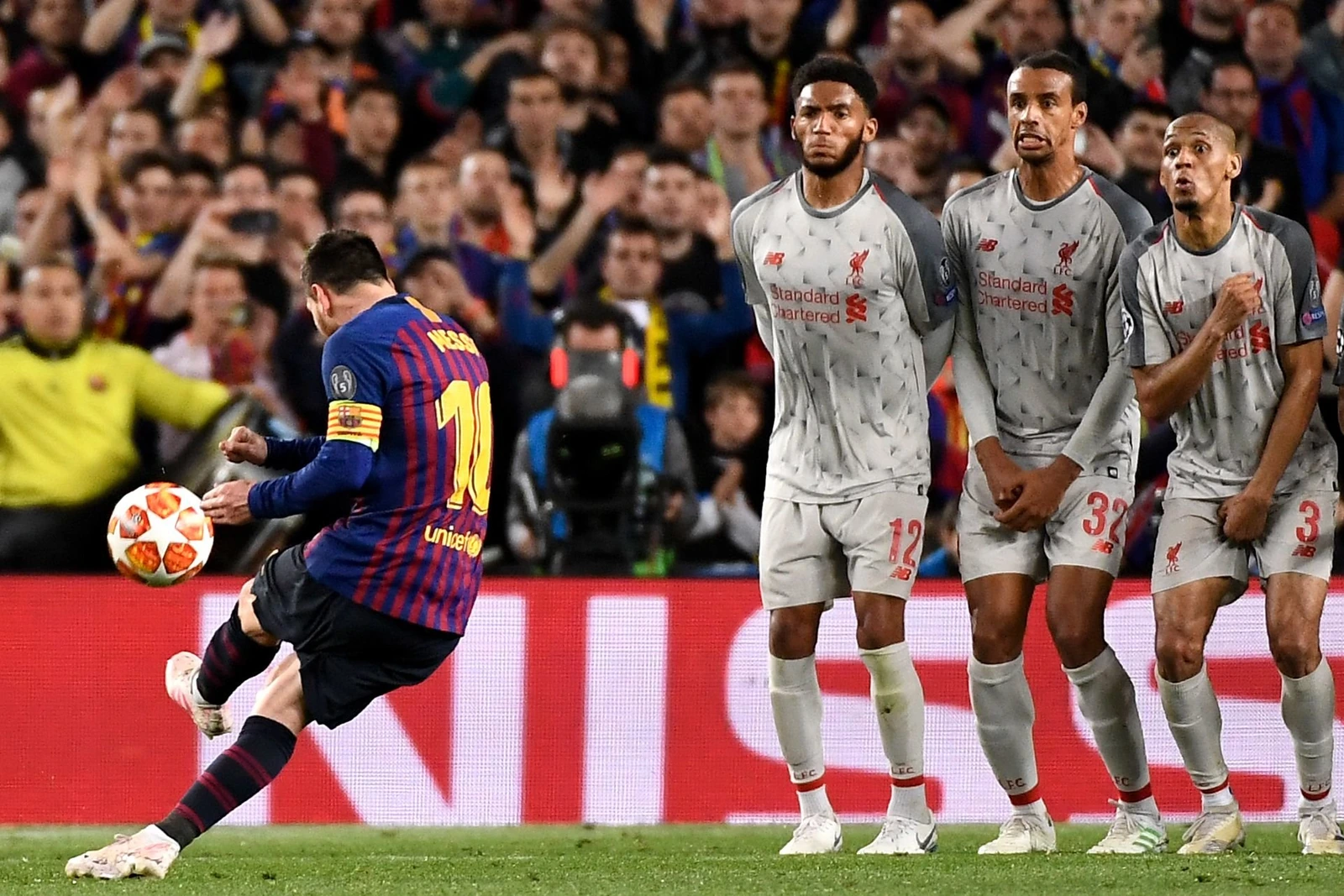 A football player taking a free kick against a defensive wall